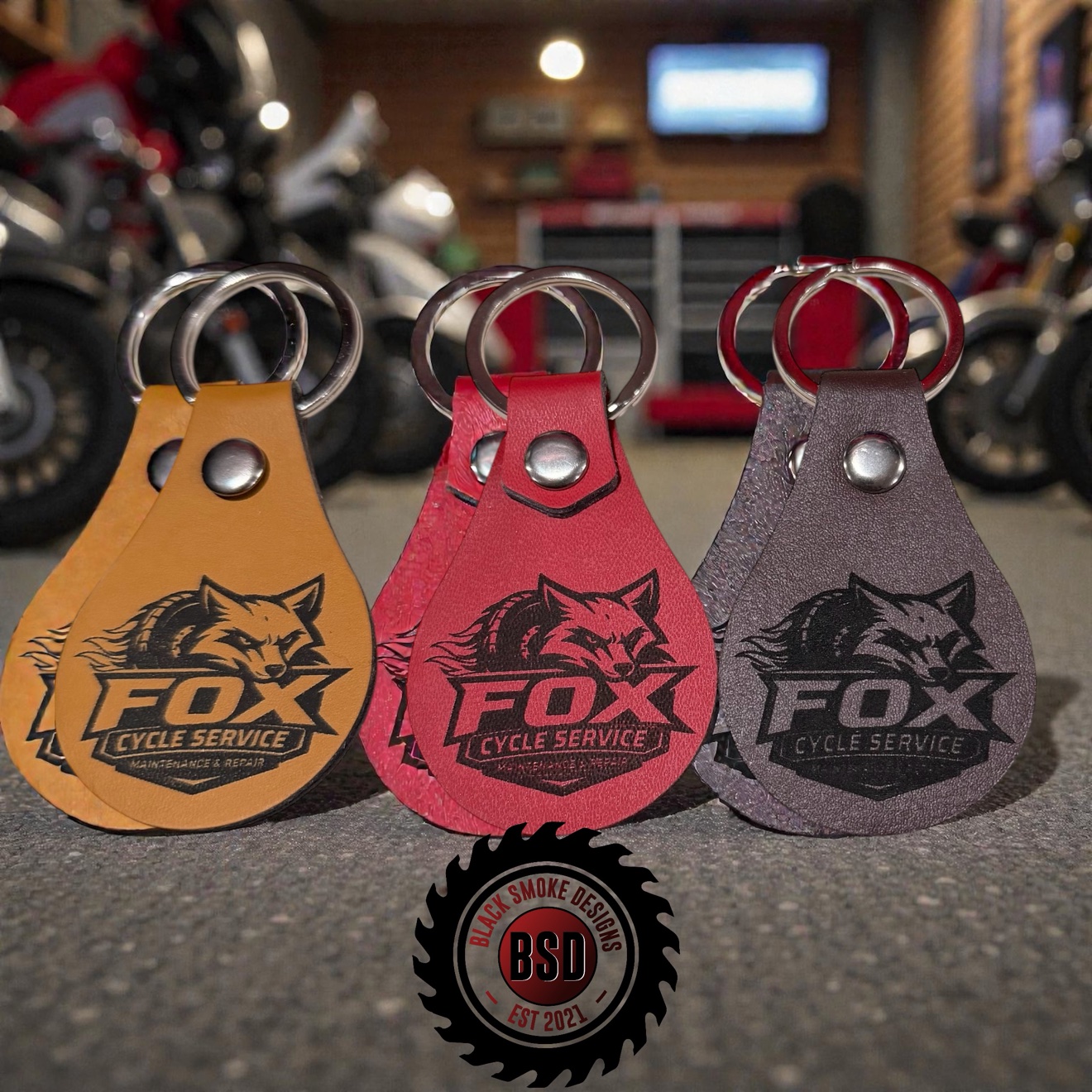 Business logo laser engraved on tan, red, and brown leatherette keychains